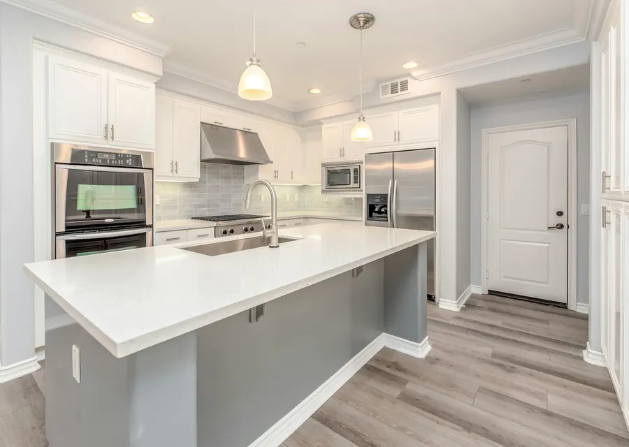 A bright white kitchen with stainless steel appliances